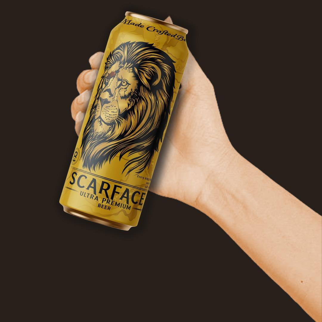 A chilled Scarface beer bottle with bold label design and golden foam, placed on a wooden table under warm ambient lighting.